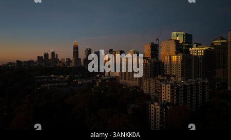 Blick aus der Vogelperspektive auf die pulsierende Skyline mit beleuchteten Wolkenkratzern und die geschäftige Stadtlandschaft bei Nacht, Midtown, Atlanta, Georgia, USA. Stockfoto