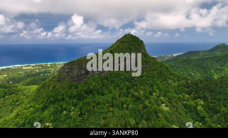 Blick aus der Vogelperspektive auf die üppigen tropischen Berge und die ruhige Küste mit atemberaubendem Meer, Avarua, Cook Islands. Stockfoto