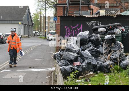 Spring Road, Acocks Green, Birmingham, 15. April 2025: Ein Mann geht an fliegengeschüttelten Müll vorbei an der Spring Road in Birmingham. - Da die Müllarbeiter weiterhin mit Unterstützung der Unite Union streiken, leiden die Gebiete in Birmingham immer noch unter dem Abfall, der außerhalb von Häusern und Unternehmen verbleibt. Ein großer Stapel Müllsäcke wurde vor einem Schild mit dem Hinweis „kein Abladen“ auf der Spring Road im Acocks Green Area der Stadt vor Geldstrafen von bis zu 20.000 Pfund zurückgelassen. Quelle: British News und Media/Alamy Live News Stockfoto