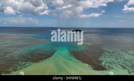 Aus der Vogelperspektive auf eine ruhige tropische Insel, umgeben von einer wunderschönen türkisfarbenen Lagune und Korallenriff, Atua, Samoa. Stockfoto