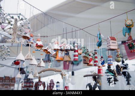 Designer-Dekorationselemente und Souvenirs in Form von Leuchttürmen, Glocken, Häusern und Engeln, handgefertigt, in einem Marktstand bei angezeigt Stockfoto