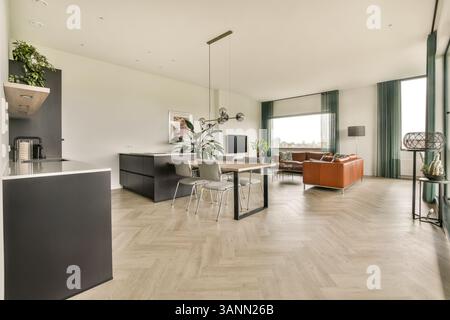 Geräumiges, modernes Wohnzimmer mit stilvollen Möbeln, eleganter Einrichtung und viel Tageslicht schaffen eine warme und einladende Atmosphäre. Stockfoto