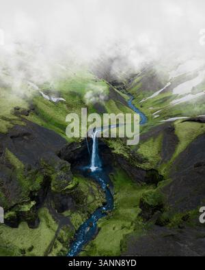 Aus der Vogelperspektive des Kvernufoss-Wasserfalls, von den Wolken im grünen Tal in Südisland aus gesehen. Stockfoto