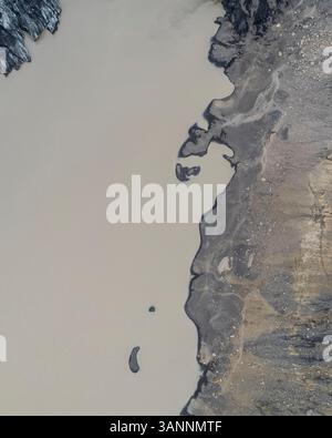 Aus der Vogelperspektive auf eine felsige Küste entlang des Sees, im Süden Islands. Stockfoto