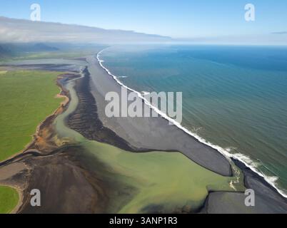 Blick aus der Vogelperspektive auf den schwarzen Sandstrand mit Küste, Holt, Island. Stockfoto