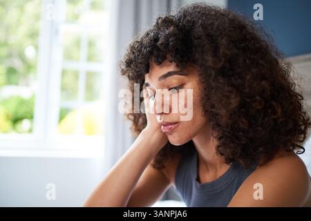 Porträt einer nachdenklichen jungen Frau zu Hause unter natürlicher Beleuchtung Stockfoto
