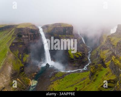 Luftaufnahme des Haifoss Wasserfalls in der südlichen Region Islands während eines nebeligen Tages. Stockfoto