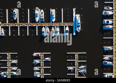 Aus der Vogelperspektive von Yachten und Segelbooten in der späten Nachmittagssonne im frühen Frühjahr in einem Yachthafen in Michigan City IN den USA Stockfoto