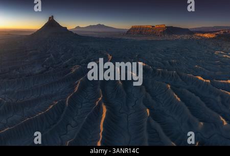 Bei Sonnenaufgang in Hanksville, Utah, USA, aus der Vogelperspektive majestätische Felsformationen und zerklüftete Berge in einer riesigen Wüstenlandschaft. Stockfoto