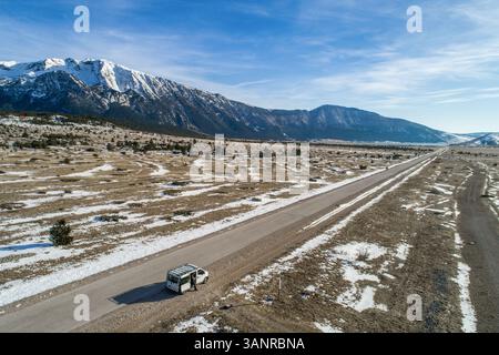 Luftaufnahme der Winterlandschaft des berühmten Blidinje Naturparks in Bosnien und Herzegowina und Minibus auf der Straße durch den Park. Stockfoto