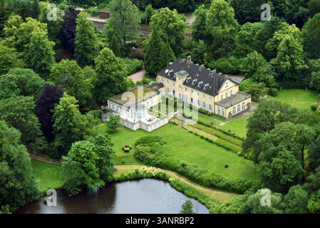 Blick aus der Vogelperspektive auf elegante Villen und ein charmantes Bauernhaus umgeben von üppigem Grün und einem ruhigen See, Aumuhle, Schleswig-Holstein, Deutschland. Stockfoto