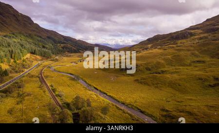 Aus der Vogelperspektive auf die Landschaft in der Nähe von Glenfinnan in Schottland mit der Eisenbahn, auf der die berühmte Jacobitendampfbahn jeden Tag vorbeifährt. Stockfoto