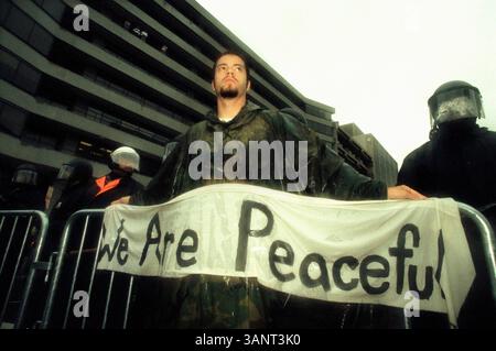 April 2000; Washington, DC, USA; ein Demonstrant steht vor der Polizei während der Proteste gegen die Weltbank/den IWF in Washington, DC, am 16. April. 2000. Stockfoto