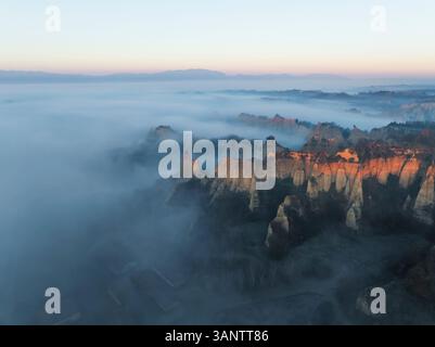 Aus der Vogelperspektive des nebeligen Sonnenaufgangs über der Balze Valdarno Landschaft, Piantravigne, Italien. Stockfoto