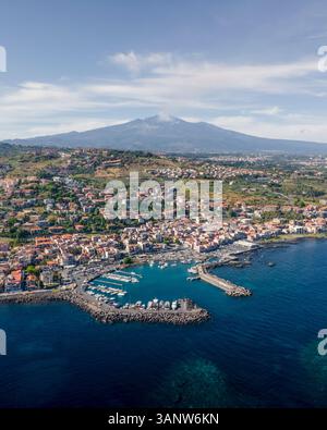 Blick aus der Vogelperspektive auf die wunderschöne Küstenstadt mit einem malerischen Hafen und verankerten Booten, ACI Castello, Sizilien, Italien. Stockfoto