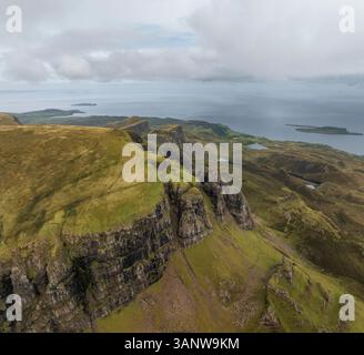 Aus der Vogelperspektive auf den majestätischen Quiraing Berg mit zerklüfteten Klippen und dem ruhigen Meer, Portree, Schottland. Stockfoto