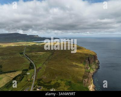 Blick aus der Vogelperspektive auf zerklüftete Klippen und das ruhige Meer entlang der malerischen Küste, Portree, Schottland. Stockfoto