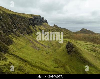 Blick aus der Vogelperspektive auf den dramatischen Quiraing Berg mit zerklüfteten Klippen und üppigem grünem Gras, Portree, Großbritannien. Stockfoto
