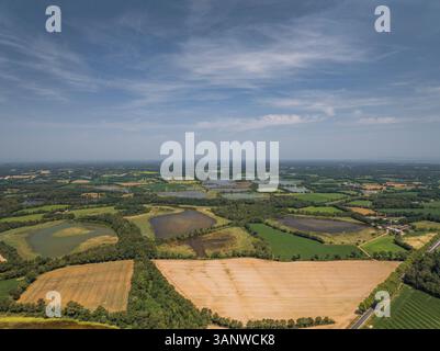 Blick aus der Vogelperspektive auf malerisches Ackerland und Wiesen unter klarem Himmel, Marlieux, Frankreich. Stockfoto