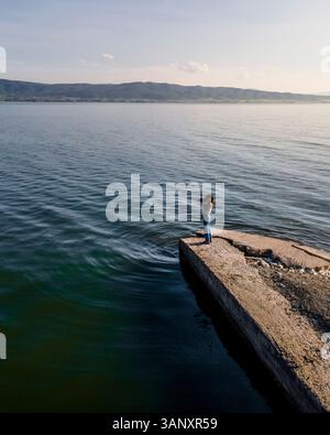 Luftaufnahme einer Frau, die Fotos entlang der Küste des Volvi-Sees in Mirki Volvi, Zentralmakedonien, Griechenland macht. Stockfoto
