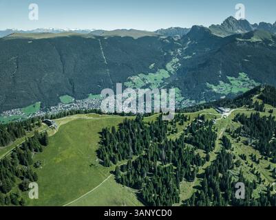 Aus der Vogelperspektive auf den Bergrücken auf der Seiser Alm auf den Dolomiten mit der Stadt St. Ulrich im Hintergrund, Trentino, Südtirol in Norditalien. Stockfoto