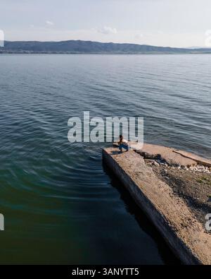 Luftaufnahme einer Frau, die Fotos entlang der Küste des Volvi-Sees in Mirki Volvi, Zentralmakedonien, Griechenland macht. Stockfoto