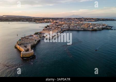 Luftaufnahme der Insel Ortigia und des Schlosses Maniace mit dem Ätna bei Sonnenuntergang in Syrakus, Sizilien, Italien. Stockfoto