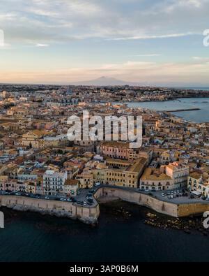 Luftaufnahme der Insel Ortigia mit dem Ätna im Hintergrund bei Sonnenuntergang in Syrakus, Sizilien, Italien. Stockfoto