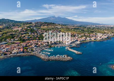Luftaufnahme von Aci Trezza, einer kleinen Stadt entlang der Küste mit Vulkan Ätna im Hintergrund, Sizilien, Italien. Stockfoto