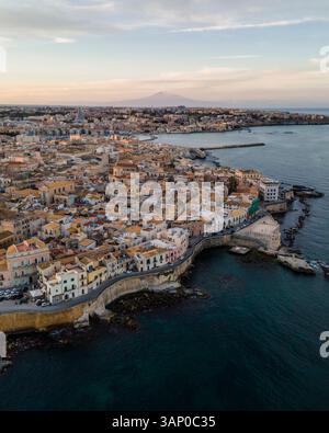 Luftaufnahme der Insel Ortigia mit dem Ätna im Hintergrund bei Sonnenuntergang in Syrakus, Sizilien, Italien. Stockfoto