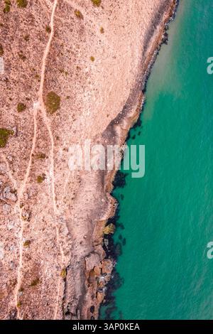 Aus der Vogelperspektive vulkanischer Boden an den Klippen entlang der Küste mit Blick auf den Atlantik in der Nähe von Sagres, Algarve, Portugal. Stockfoto