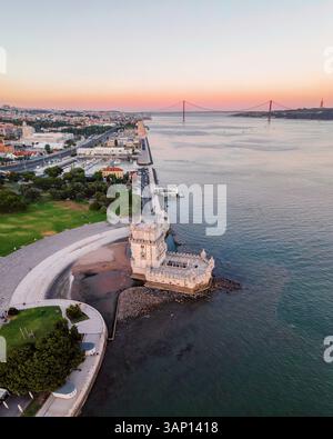 Panoramablick auf den Turm von Belem bei Sonnenuntergang mit Brücke vom 25. April im Hintergrund, Lissabon, Portugal. Stockfoto
