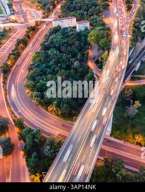 Luftaufnahme von Fahrzeugen, die bei Sonnenuntergang auf der Autobahn in Lissabon fahren, Alcântara, Lissabon, Portugal. Stockfoto