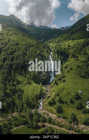 Drohnenblick auf den Wasserfall Cascata La Froda in Sonogno, umgeben von üppig grünen Gras und Bäumen, Verzasca, Schweiz. Stockfoto