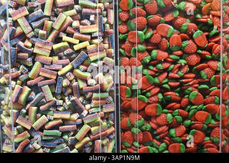 Bunte Gummibonbons in Plastikbehältern im Süßwarenladen. Rote Erdbeeren, zuckersüß Stockfoto
