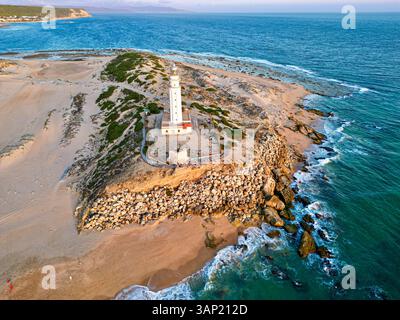 Aus der Vogelperspektive auf die wunderschöne Küste mit Klippen und einem Leuchtturm am Cape Trafalgar, Barbate, Spanien. Stockfoto