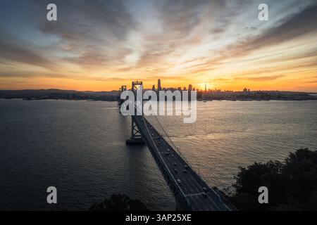 Blick aus der Vogelperspektive auf die Bay Bridge und die wunderschöne Skyline bei Sonnenuntergang über dem Wasser, Treasure Island, Kalifornien, USA. Stockfoto