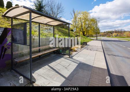 Eine leere Bushaltestelle am Straßenrand an einem Frühlingstag. Überdachte Bushaltestelle. Hochwertige Fotos Stockfoto
