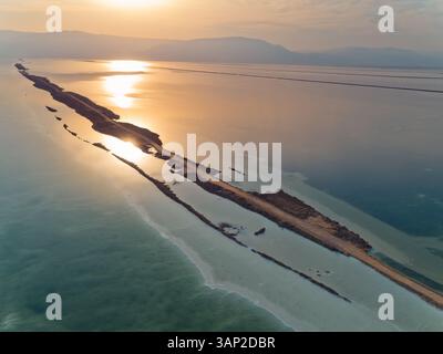 Aus der Vogelperspektive auf den Sonnenaufgang über farbenfrohen Salzadern im Toten Meer und Berge im Hintergrund, Totes Meer, Negev, Israel. Stockfoto