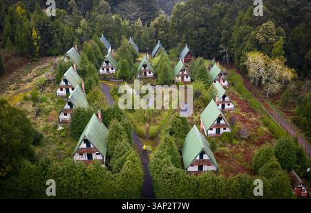 Aus der Vogelperspektive eines Mannes in gelber Jacke um verlassene Häuser, Santana, Madeira Island, Portugal. Stockfoto