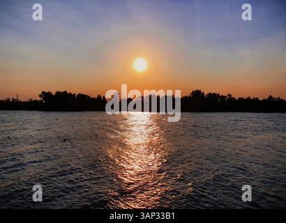 Farbenfroher Sonnenuntergang über dem Cape Fear River, vom Wilmington Riverwalk im historischen Stadtzentrum von Wilmington, North Carolina, USA Stockfoto