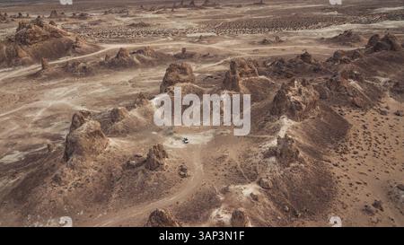 Aus der Vogelperspektive eines SUV-Autos umgeben von Felsformationen in einer Wüstennera Trona Pinnacles in Kalifornien, USA. Stockfoto