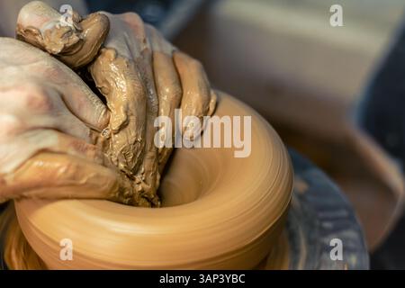 Nahaufnahme der Hände eines männlichen Töpfers, der eine Vase bastelt. Töpferwaren. Keramikherstellung. Stockfoto