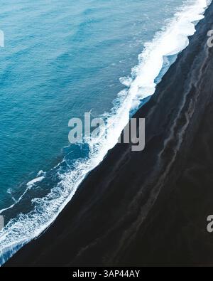 Von oben aus der Drohne blickt man auf den endlosen Black Beach und den blauen Atlantik, Dyrholaey Beach, Südisland. Stockfoto