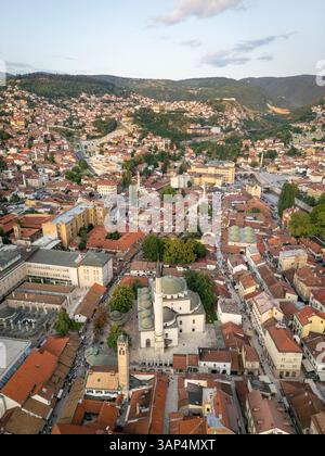 Blick aus der Vogelperspektive auf Bascarsija mit der historischen Gazi Husrev-Beg Moschee und mittelalterlichen Häusern umgeben von Bergen und Grün, Sarajevo, Bosnien und Herz Stockfoto