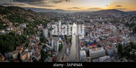 Blick aus der Vogelperspektive auf Bascarsija und den Miljacka-Fluss bei Sonnenuntergang mit malerischen Hügeln und historischen Gebäuden, Sarajevo, Bosnien und Herzegowina. Stockfoto