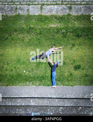 Luftaufnahme einer schwangeren Frau, die über den Mann springt, entlang des Flusses Drava in Osijek, Osijek-Baranja, Kroatien. Stockfoto
