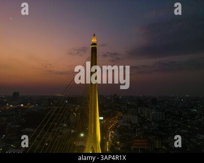 Aus der Vogelperspektive auf die Rama VIII Brücke, eine Kabelbrücke über den Chao Phraya Fluss bei Nacht in Bangkok, Thailand. Stockfoto