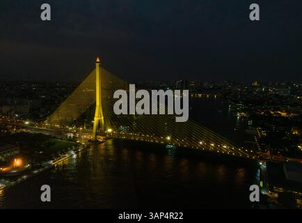Aus der Vogelperspektive auf die Rama VIII Brücke, eine Kabelbrücke über den Chao Phraya Fluss bei Nacht in Bangkok, Thailand. Stockfoto