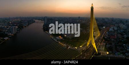Aus der Vogelperspektive auf die Rama VIII Brücke, eine Kabelbrücke über den Chao Phraya Fluss bei Nacht in Bangkok, Thailand. Stockfoto